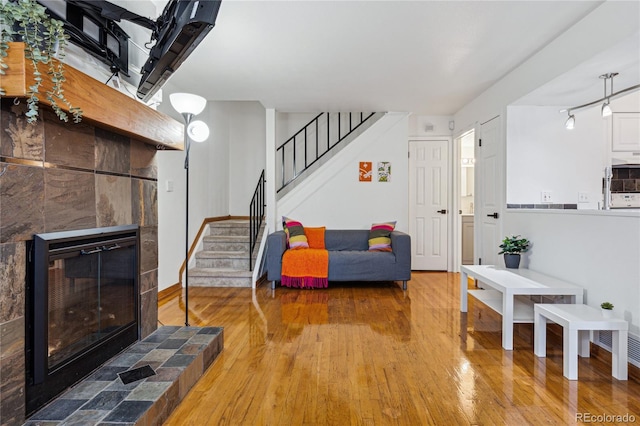 living room featuring hardwood / wood-style flooring and a tiled fireplace