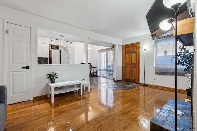 entryway featuring plenty of natural light, an inviting chandelier, and dark hardwood / wood-style floors