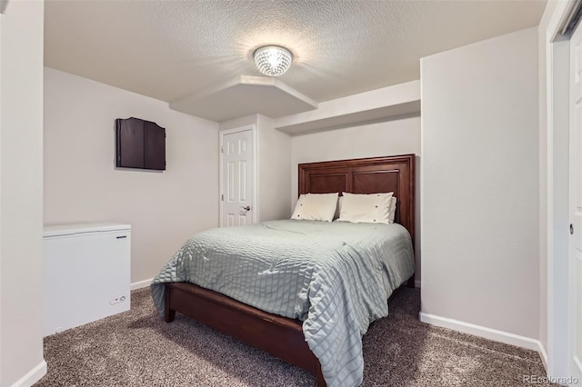 bedroom featuring dark colored carpet, a textured ceiling, a closet, and fridge