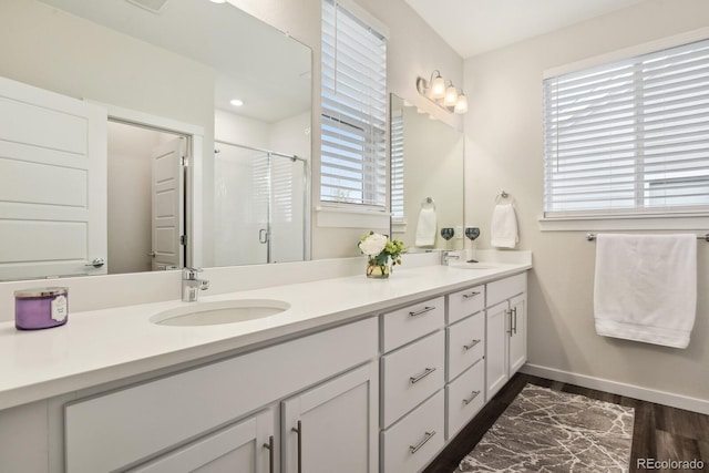 11151 W 53rd Dr, Wheat Ridge, CO 80033 - bathroom with double vanity, a stall shower, and wood finished floors