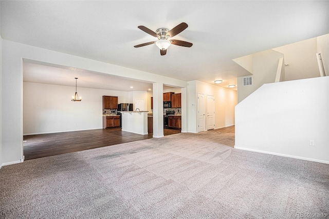 unfurnished living room with carpet floors, visible vents, baseboards, and a ceiling fan