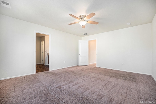 empty room featuring carpet, visible vents, and baseboards