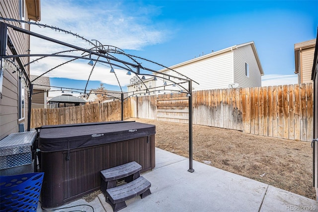 view of patio featuring a hot tub and a fenced backyard