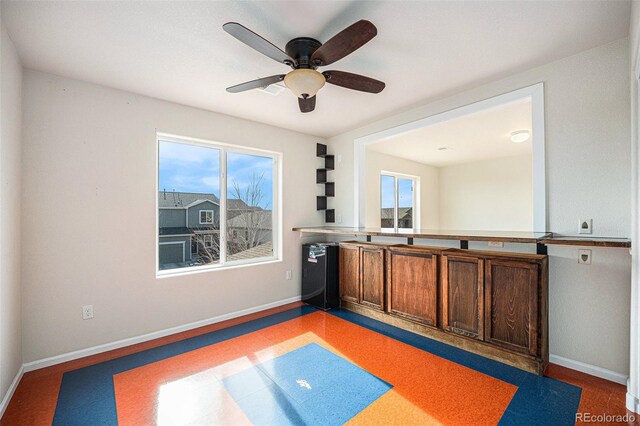 interior space featuring ceiling fan and baseboards