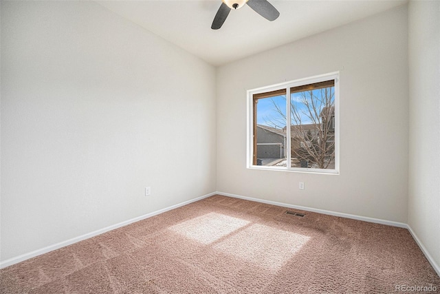 carpeted spare room featuring baseboards, visible vents, and a ceiling fan