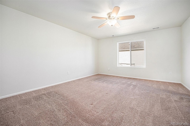 carpeted spare room featuring baseboards, visible vents, ceiling fan, and a textured ceiling