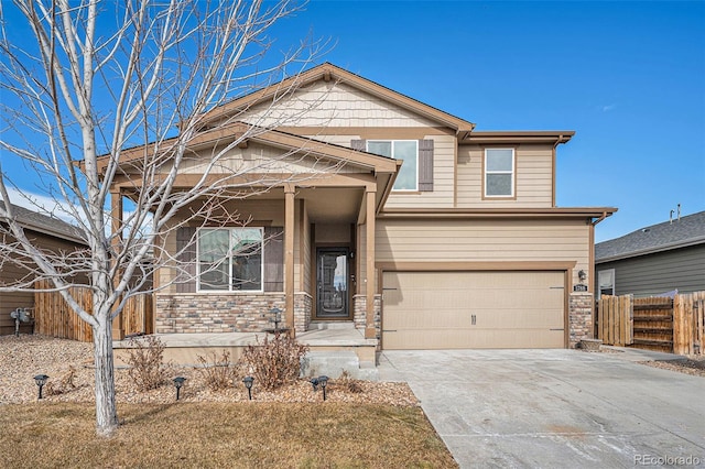 view of front of home featuring a garage, stone siding, fence, and concrete driveway