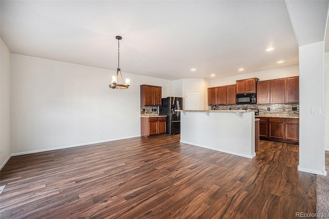 kitchen with black microwave, a kitchen breakfast bar, stainless steel fridge with ice dispenser, dark wood-style floors, and an inviting chandelier