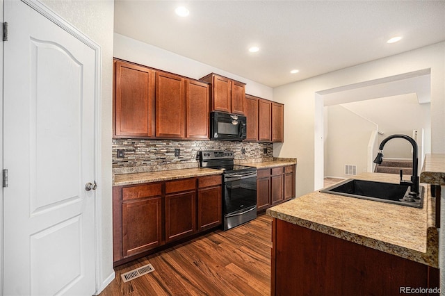 kitchen with black microwave, dark wood-style flooring, a sink, visible vents, and stainless steel range with electric stovetop