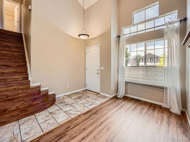 3708 S Lisbon Way, Aurora, CO 80013 - entryway with stairs, a towering ceiling, plenty of natural light, and wood finished floors