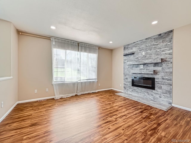 3708 S Lisbon Way, Aurora, CO 80013 - unfurnished living room featuring a fireplace, wood finished floors, and recessed lighting