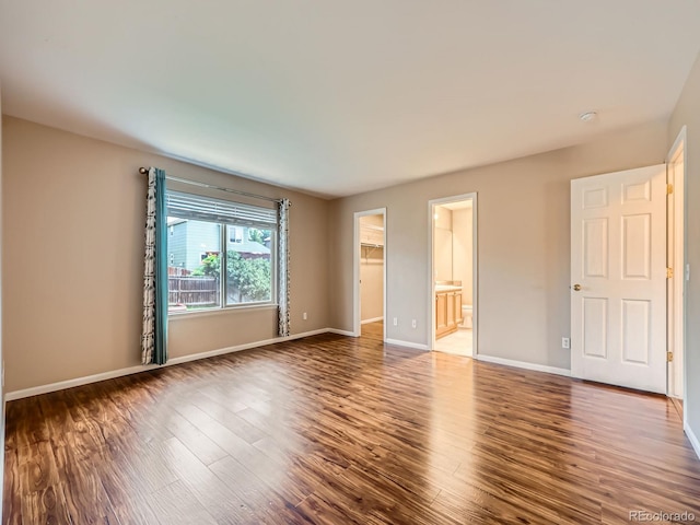 3708 S Lisbon Way, Aurora, CO 80013 - unfurnished bedroom with a walk in closet, wood finished floors, and ensuite bath