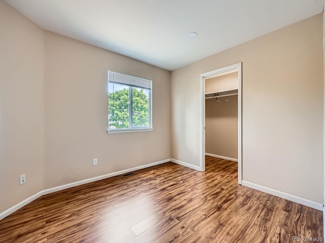 3708 S Lisbon Way, Aurora, CO 80013 - unfurnished bedroom featuring wood finished floors and a walk in closet
