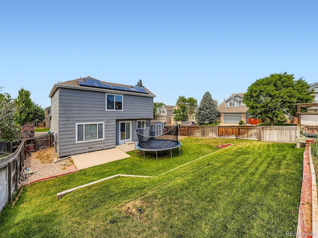 3708 S Lisbon Way, Aurora, CO 80013 - rear view of property featuring a trampoline, solar panels, a fenced backyard, and a patio area