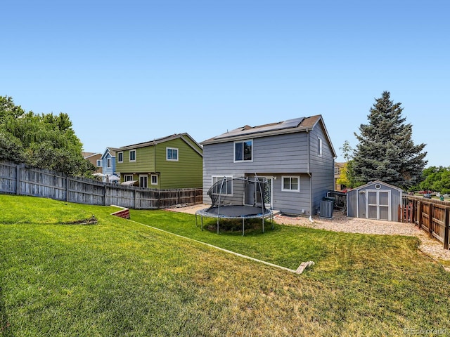 3708 S Lisbon Way, Aurora, CO 80013 - rear view of house featuring a trampoline, a storage unit, a fenced backyard, and solar panels