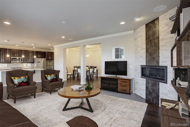 living room with crown molding, dark wood-type flooring, and a fireplace