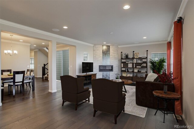 living room with wood-type flooring, a notable chandelier, and crown molding