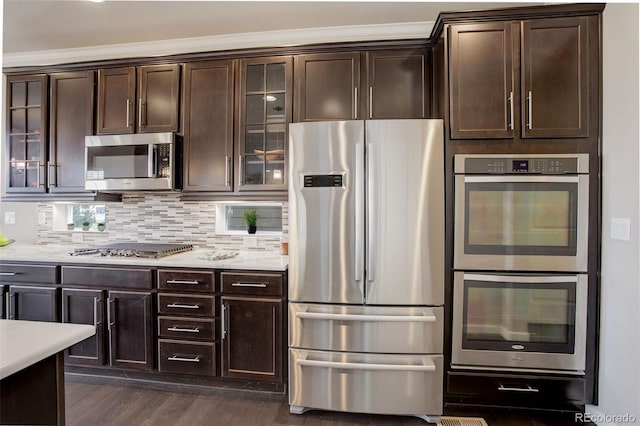 kitchen featuring stainless steel appliances, dark hardwood / wood-style flooring, backsplash, and dark brown cabinetry