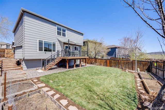rear view of property with stairway, a lawn, a deck, a fenced backyard, and a garden