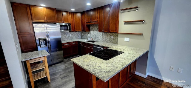 kitchen with backsplash, a peninsula, dark wood-style floors, stainless steel appliances, and a sink