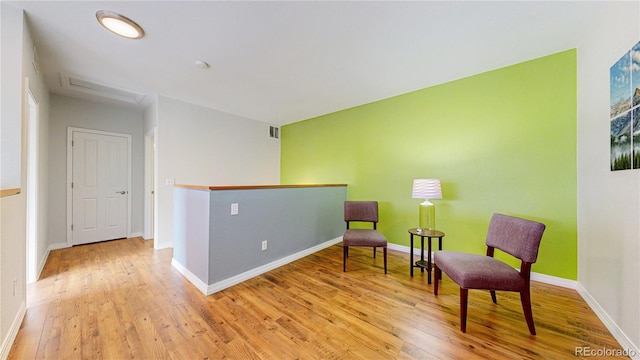 sitting room with visible vents, baseboards, and wood finished floors