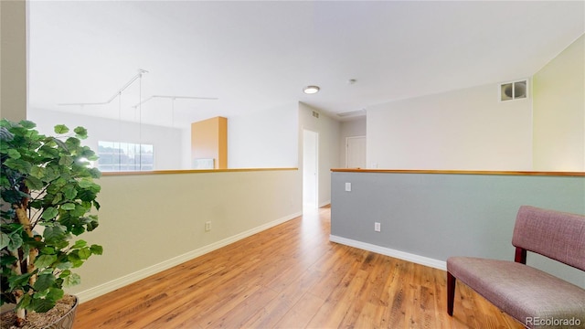 living area featuring wood finished floors, visible vents, and baseboards