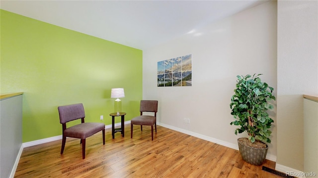 living area with visible vents, light wood-style flooring, and baseboards