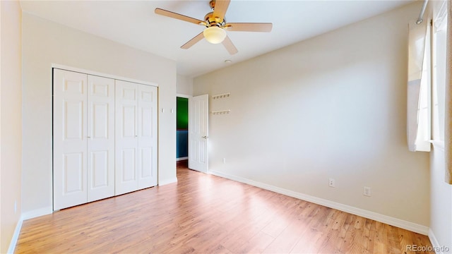 unfurnished bedroom featuring a closet, baseboards, and light wood-style flooring