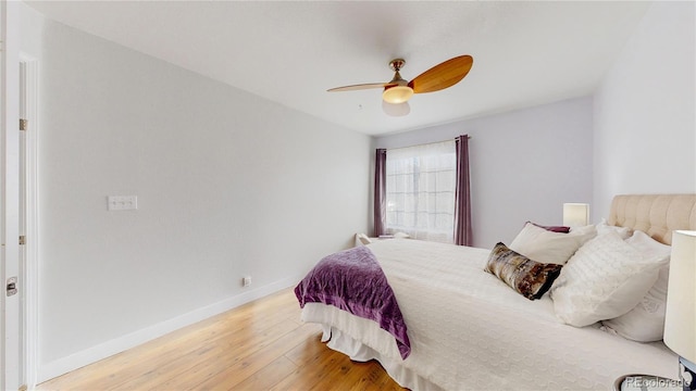 bedroom featuring a ceiling fan, baseboards, and wood finished floors