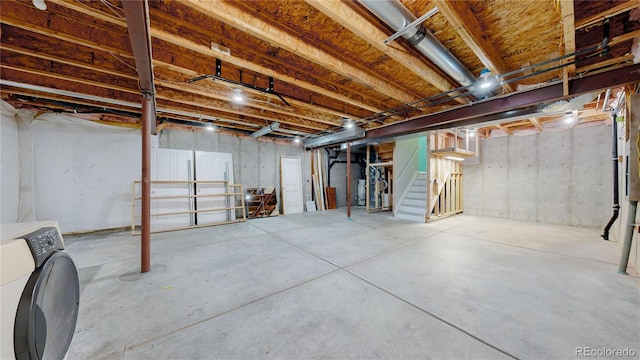 unfinished basement with stairs and washer / clothes dryer