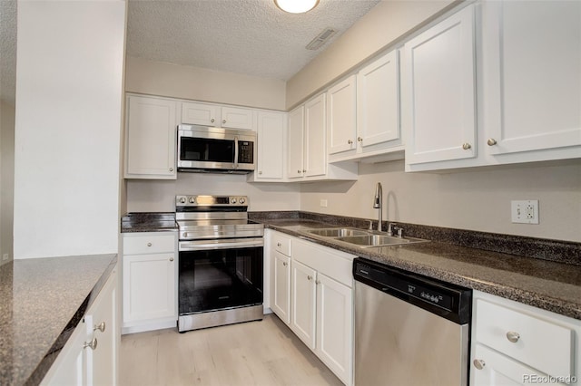 kitchen featuring white cabinets, appliances with stainless steel finishes, and a sink