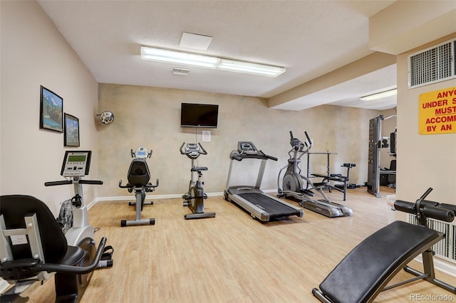 gym with visible vents, baseboards, and wood finished floors