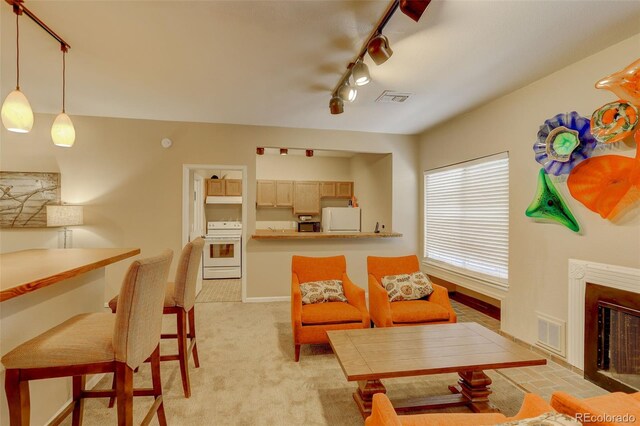 living area featuring visible vents, baseboards, light colored carpet, and a fireplace