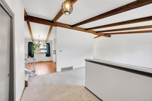 corridor featuring visible vents, lofted ceiling with beams, stairway, carpet floors, and a notable chandelier