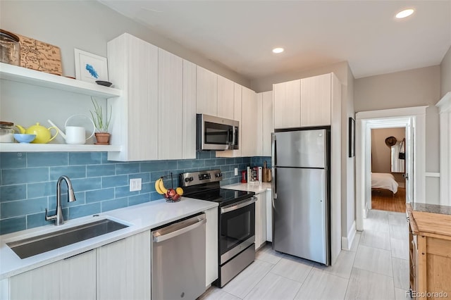 493 S Lincoln St, Denver, CO 80209 - kitchen with open shelves, a sink, stainless steel appliances, light countertops, and backsplash