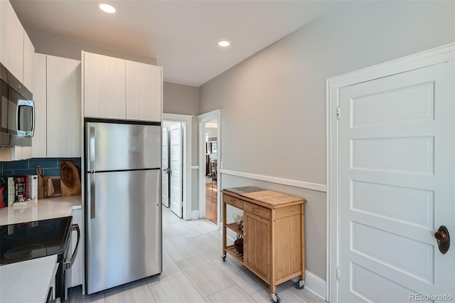 493 S Lincoln St, Denver, CO 80209 - kitchen with recessed lighting, light countertops, modern cabinets, baseboards, and appliances with stainless steel finishes