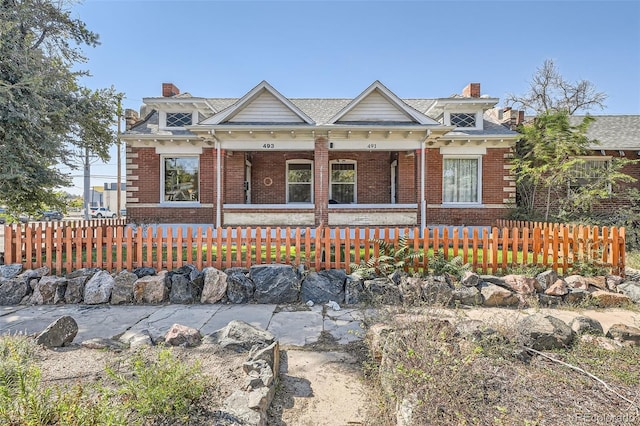 493 S Lincoln St, Denver, CO 80209 - view of front of house featuring brick siding, a fenced front yard, a chimney, and covered porch