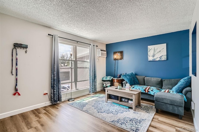 living room with a textured ceiling, a wall mounted AC, and hardwood / wood-style flooring