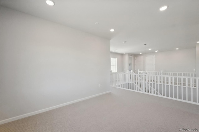 carpeted spare room featuring recessed lighting and baseboards