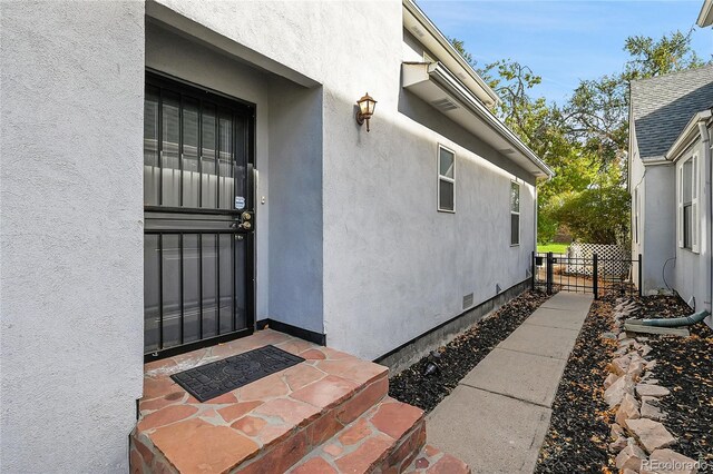 1431 Tamarac St, Denver, CO 80220 - entrance to property with stucco siding, fence, and crawl space