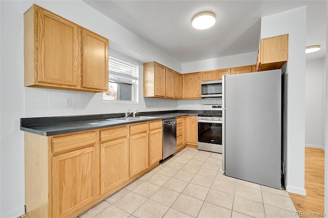 kitchen featuring light brown cabinets, light tile patterned floors, backsplash, sink, and stainless steel appliances