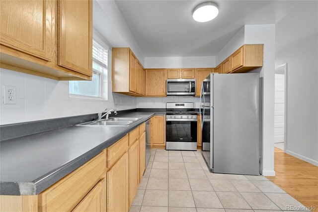 1431 Tamarac St, Denver, CO 80220 - kitchen with light tile patterned flooring, a sink, dark countertops, tasteful backsplash, and appliances with stainless steel finishes