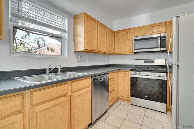 1431 Tamarac St, Denver, CO 80220 - kitchen featuring light tile patterned floors, dark countertops, appliances with stainless steel finishes, and a sink