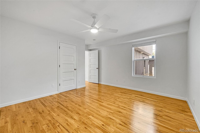 empty room with ceiling fan and light hardwood / wood-style flooring