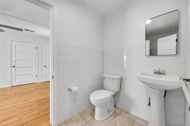 1431 Tamarac St, Denver, CO 80220 - bathroom featuring tile walls, toilet, visible vents, and a ceiling fan