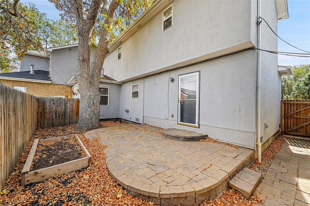 1431 Tamarac St, Denver, CO 80220 - back of house featuring a patio, stucco siding, a garden, and a fenced backyard