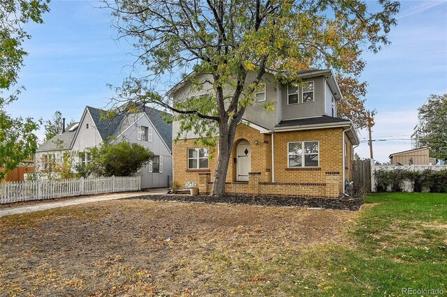 1431 Tamarac St, Denver, CO 80220 - view of front of property with a front yard, stucco siding, brick siding, and fence