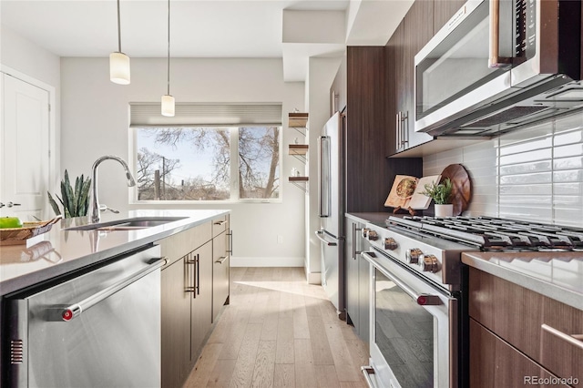 kitchen featuring modern cabinets, a sink, high quality appliances, and plenty of natural light