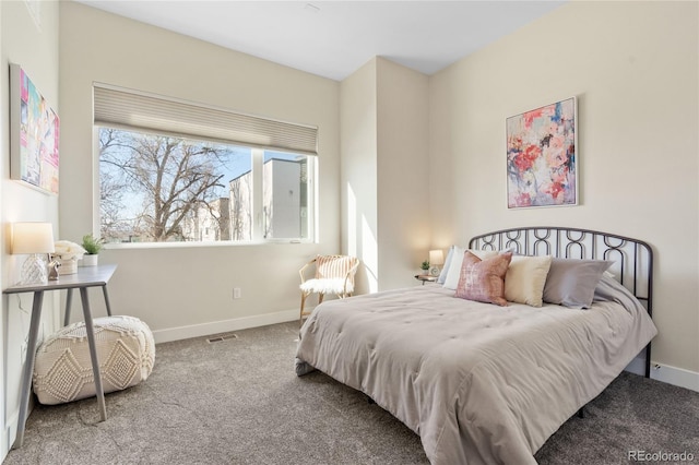 bedroom with baseboards, visible vents, and carpet