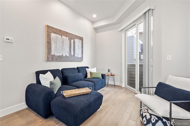 living room featuring baseboards, light wood finished floors, and recessed lighting